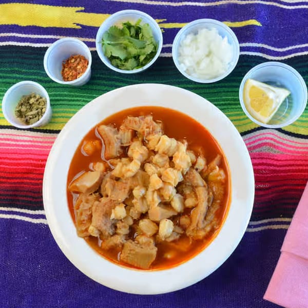 La Casita Mexican Grill's menudo, a traditional Mexican soup, with sides of cilantro, onions, spices, and lemon.