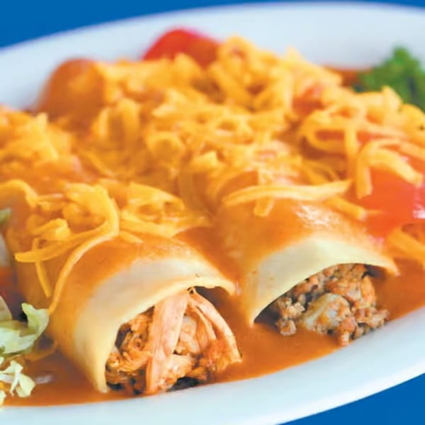 Two enchiladas, one chicken and one beef, covered in red sauce and shredded cheese, with lettuce and tomato.